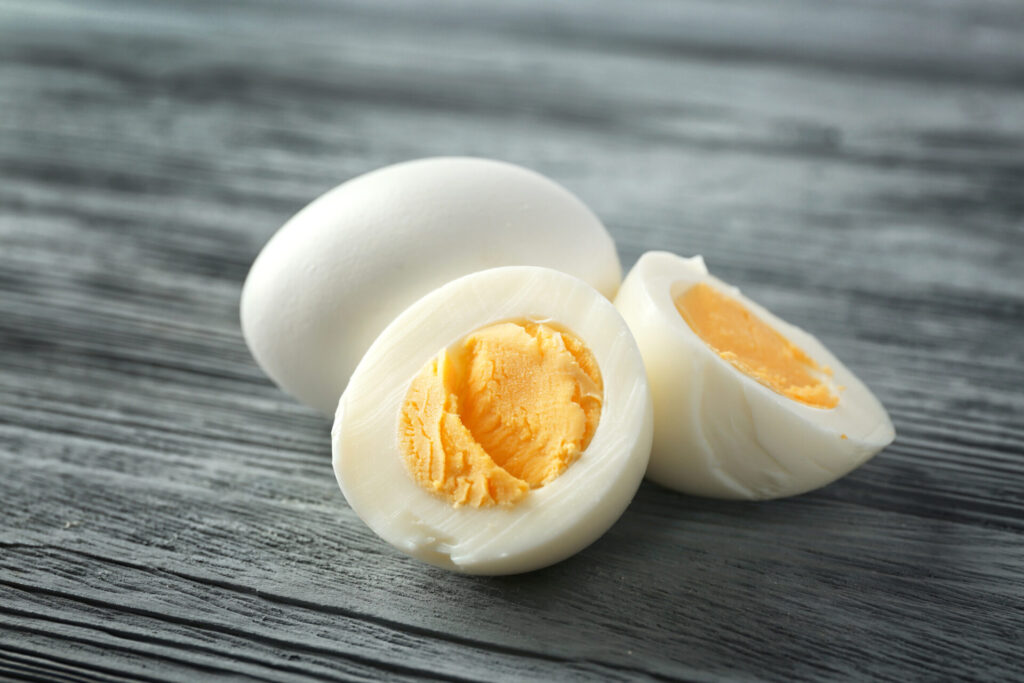 Hard boiled eggs on wooden background.